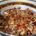 Piatto tipico del borgo, servito con ingredienti freschi e colorati, su un tavolo rustico.