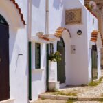 Borgo portoghese con strade acciottolate e case bianche, meta ambita dai turisti.