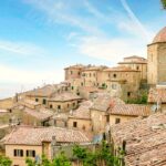 Vista panoramica del borgo ligure con focacce tipiche in primo piano.