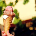 Gelato artigianale premiato in una gelateria siciliana, con vari gusti esposti e clienti soddisfatti.