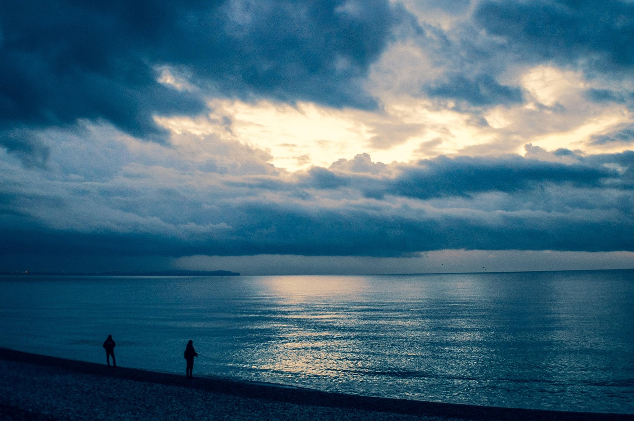 Spiaggia deserta d'inverno, onde calme e cielo grigio, un paesaggio che invita alla riflessione e alla serenità.