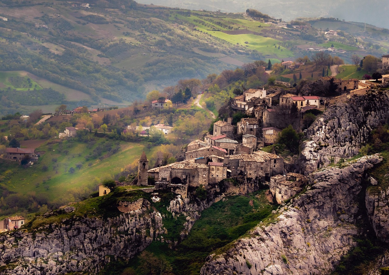 Panorama di un antico villaggio italiano immerso nella natura, con strade acciottolate e case storiche.