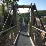 Ponte sospeso in Trentino, vista panoramica sul paesaggio montano e l'emozione dell'altezza.
