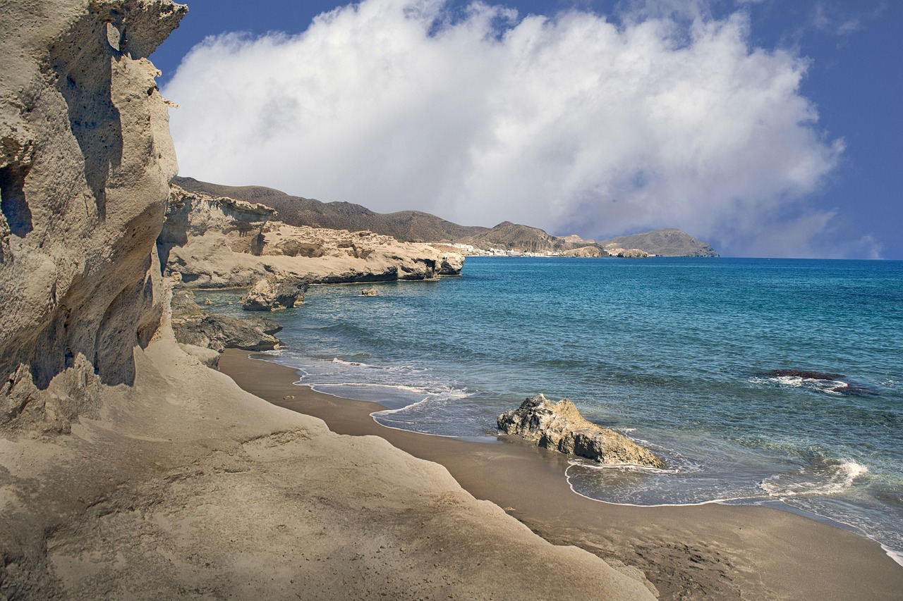 Vista panoramica di una spiaggia cristallina nell'arcipelago delle Cicladi, con sabbia bianca e acque turchesi.