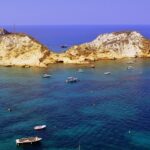 Spiaggia di Ponza con sabbia bianca e acque turchesi, simile a un paradiso tropicale.