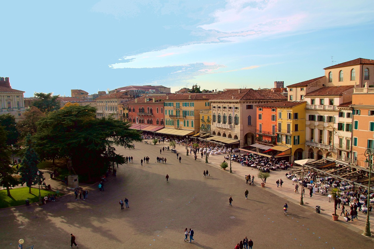 Piazza storica di Treviso con bancarelle colorate del mercato, affollata di visitatori e atmosfera vivace.