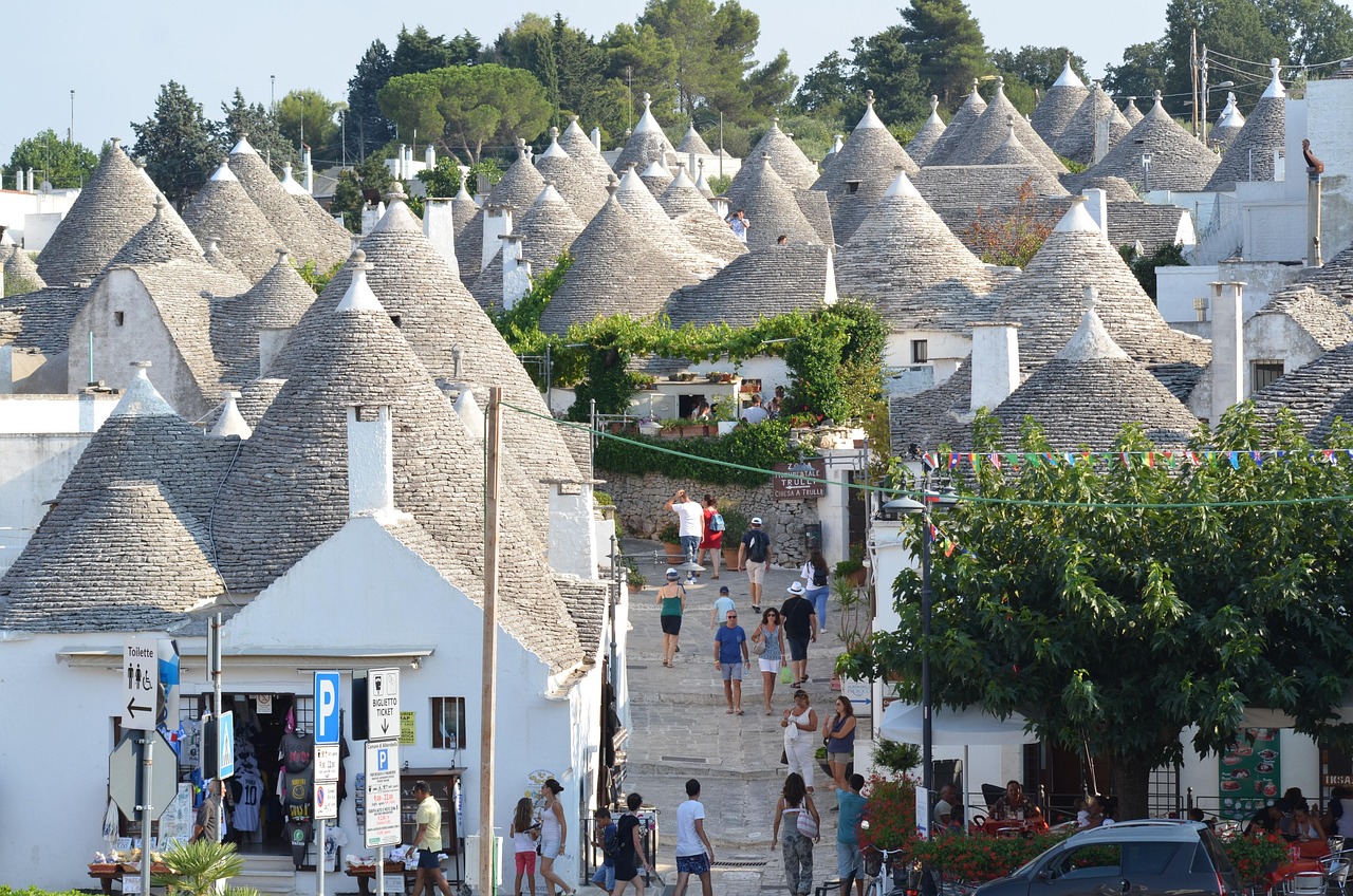 Panorama del borgo italiano con poche case affollato da turisti in visita.