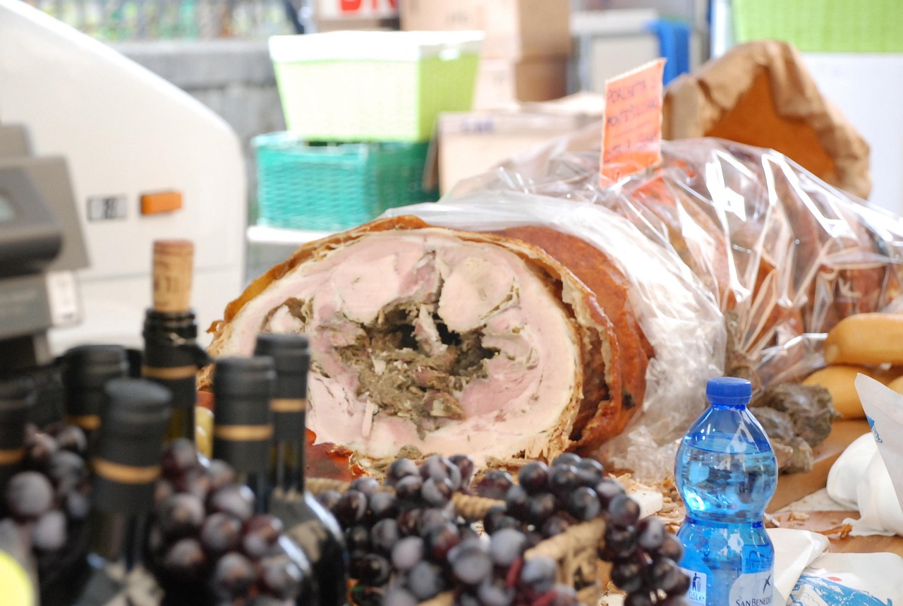 Paesaggio marchigiano con festeggiamenti per la sagra della porchetta, eventi e visitatori felici.