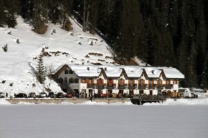 Vista panoramica del lago di Braies, affollato di turisti in una giornata di sole.