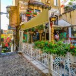 Piazza di Napoli con caffetterie affollate e turisti che gustano caffè all'aperto.